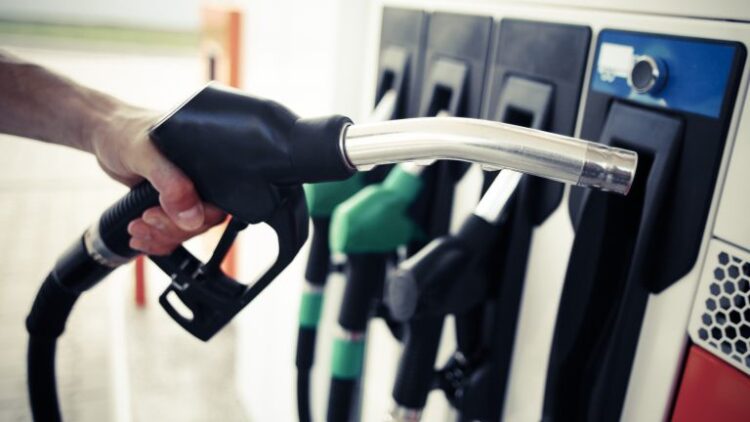 Detail of a hand holding a fuel pump at a station