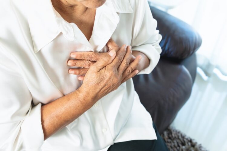 old woman having heart attack and grabbing her chest